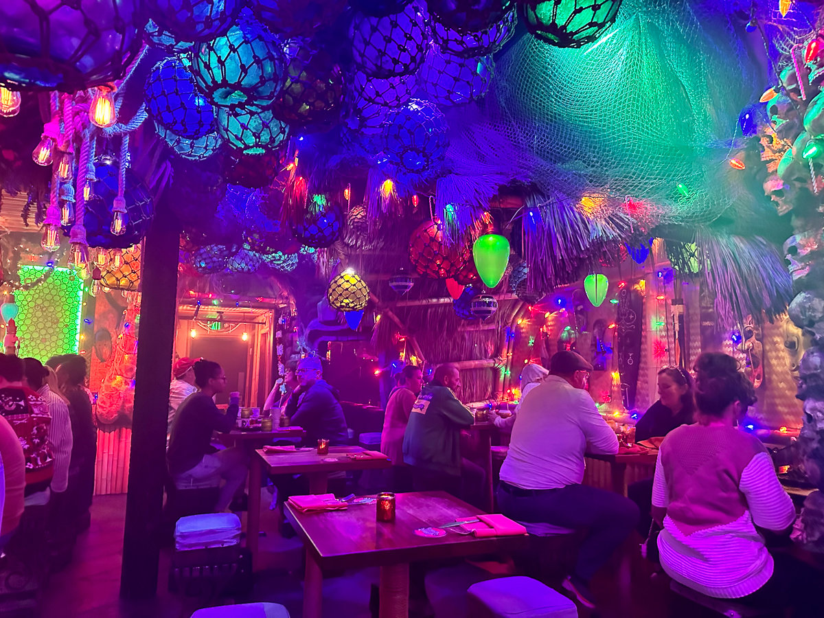bright purple and blue lights in a tiki themed bar